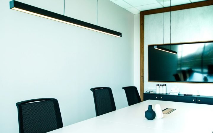 a conference room with a white table and black chairs