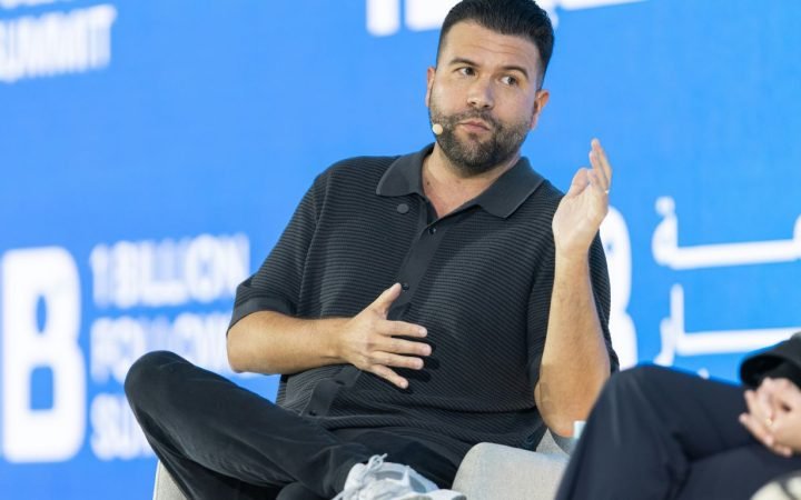 Man speaking on a panel with a blue background